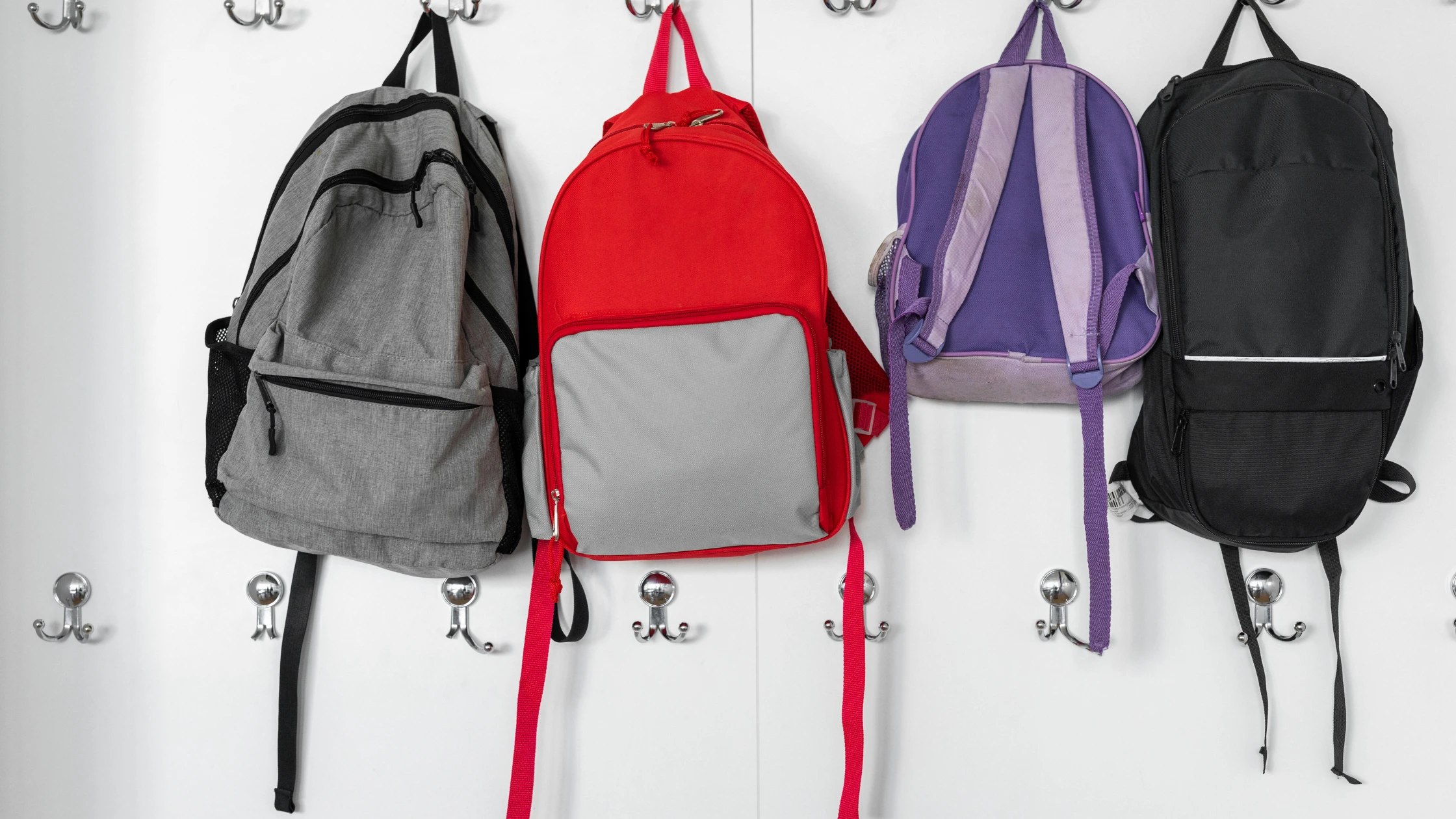 School bags hanging on classroom hooks